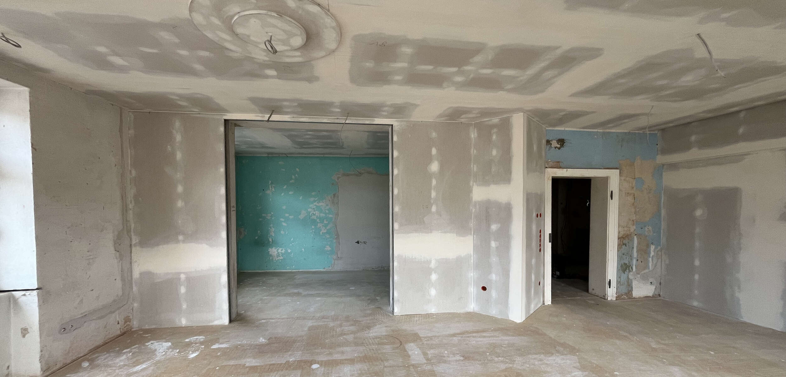 Professionelle Handwerker führen Trockenbauarbeiten auf einer Baustelle durch, ein wichtiger Schritt im Prozess des Innenarchitektur-Designs.