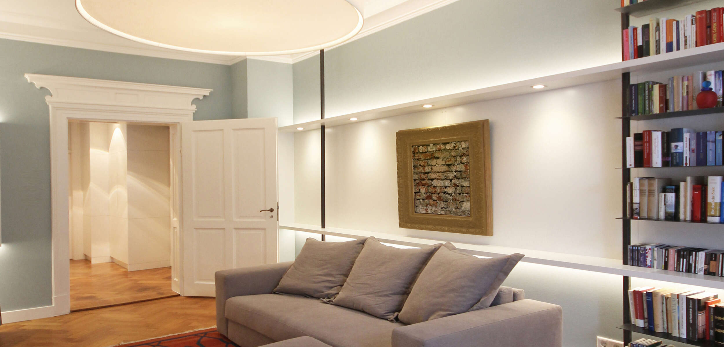 Elegantes Wohnzimmer in einem Münchner Altbau mit stilvoller Innenbeleuchtung, hohen Decken und detailreicher Innenarchitektur. 