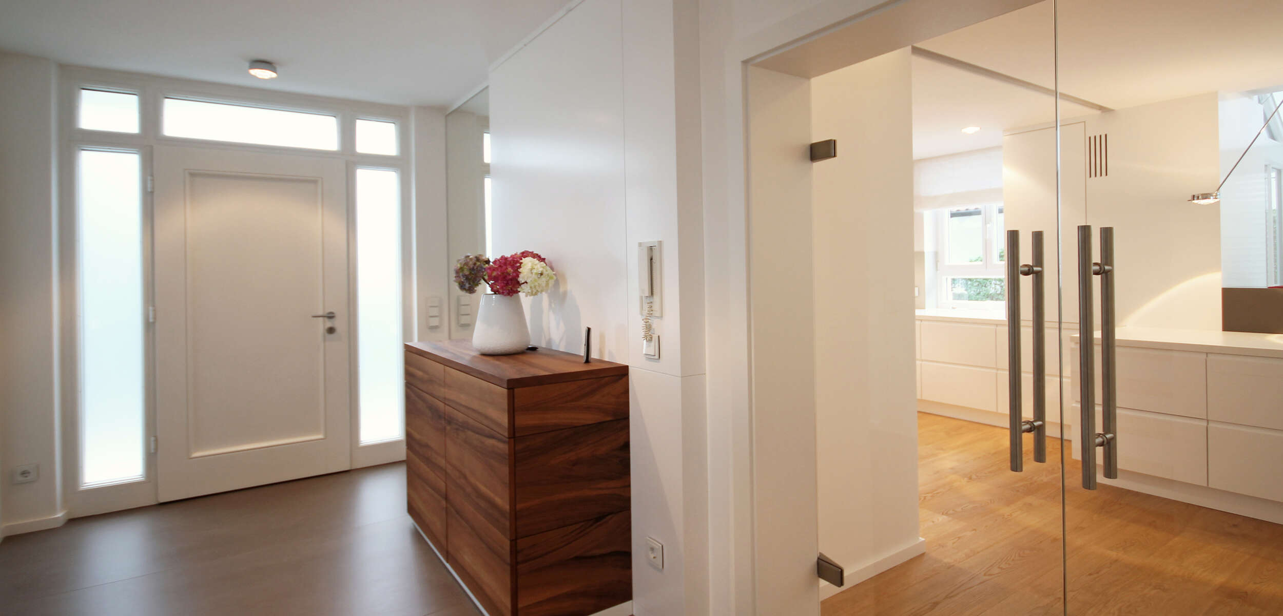 Modern gestalteter Hauseingang mit hochwertigem Dielenboden, eleganter Innenausstattung und stilvollen Möbeln durch einen Innenarchitekten in München.