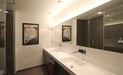 Die Handwaschbecken sind nahtlos in den Waschtisch aus Mineralguss integriert. Die Wasserhähne sind als Wandarmaturen ausgeführt. Der Spiegelschrank ist in die Wand eingebaut.