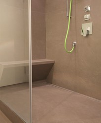 Eine gemauerte Sitzbank in der Duschkabine bietet ungewöhnlichen Komfort und Luxus. Die Ablaufrinne ist in den Boden integriert, die Entwässerung erfolgt über die Fliesenfuge.