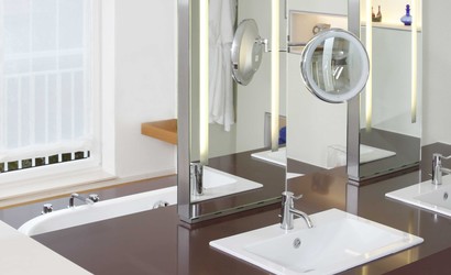 Individuell entwickelte Spiegel stehen auf dem Waschtisch mit eingebauten Handwaschbecken und ermöglichen eine Beleuchtung durch die Spiegelfläche hindurch.