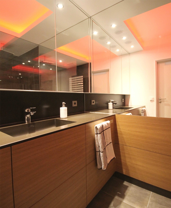 Der Spiegelschrank verläuft über die gesamte Raumseite und bietet Platz für Kosmetika und Medikamente, die Beleuchtung erfolgt über LED-Einbauspots in der Abhangdecke.