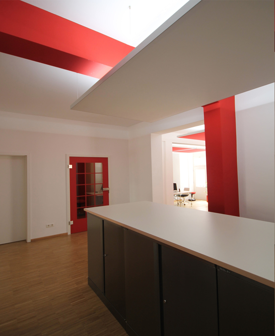 Die Aktenschränke wurden im Zentrum des Flures aufgestellt und mit einer Tischplatte belegt, so entstand ein kommunikativer Treffpunkt. Die Telefonzelle ermöglicht ungestörte Telefonate.