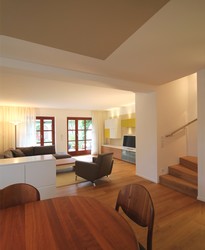 Wohnraum und Speisezimmer gehen fließend ineinander über. Farben, Materialien und Oberflächen sind aufeinander abgestimmt. Treppe aus Massivholz passt zum Parkett.