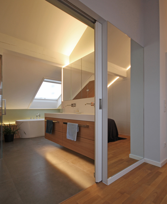 Innenarchitekt Andreas Ptatscheck, München, plante den Bestandsgrundriss des Dachgeschosses um und entwarf die Innenarchitektur und das Interior Design für das Badezimmer mit Badewanne, Waschtisch und Spiegelschrank.