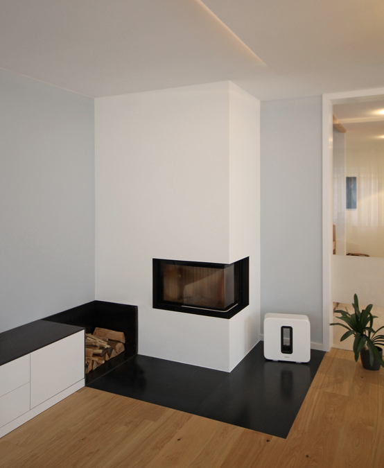 Der Kamin von Innenarchitekt und Interior Designer Andreas Ptatscheck, München, wirkt wie ein Wandausschnitt. Das Material Schwarzstahl findet sich in der Holzlege, im Funkenschutz des Bodens, in der Einfassung der Feuerstelle und auf dem Lowboard.