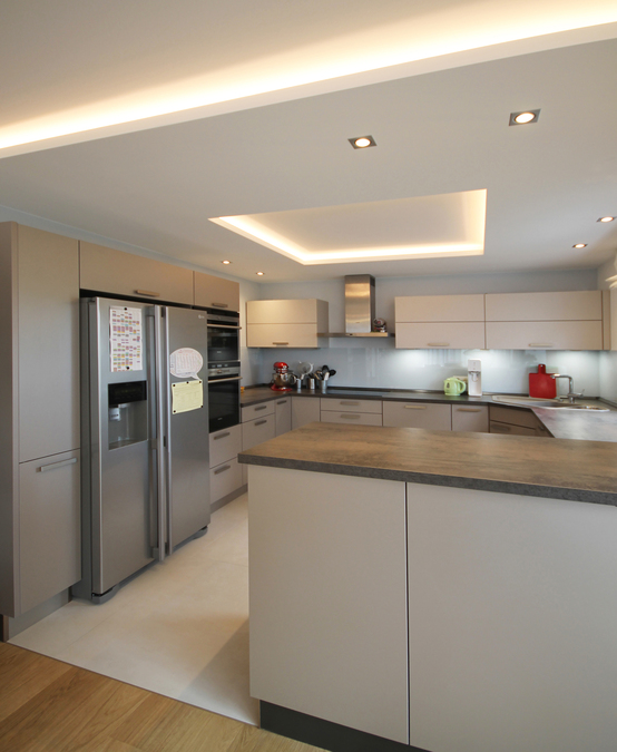 Innenarchitekt und Interior Designer Andreas Ptatscheck, München, ergänzte die bereits vor dem Umbau vorhandene Küche durch Schränke, Glasrückwände und eine Abhangdecke mit beleuchtetem Deckenfeld.