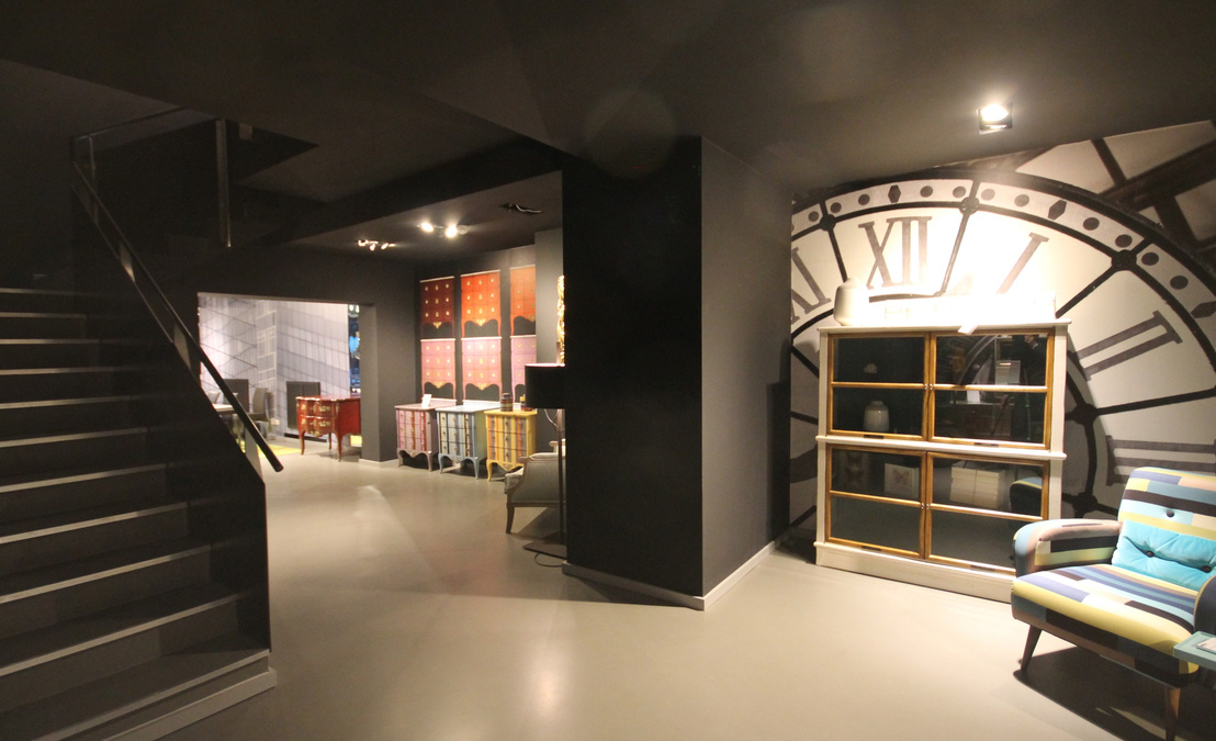 Durch Stützen getrennt strahlen die einzelnen Kojen mit ihren Tapeten vor dem dunklen Hintergrund der schwarzen Wände und Decken durch eine brillante Beleuchtung.