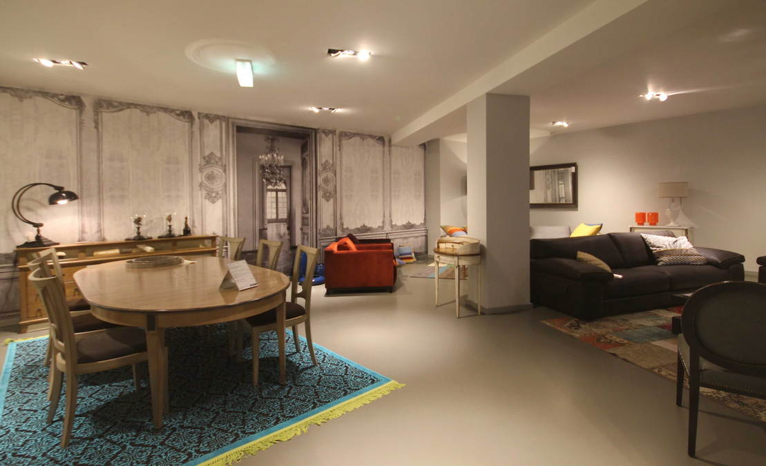 Punktgenaue Lichtspots und Strahler inszenieren die farbenfrohen Möbel vor dem dunklen Hintergrund und lassen sie strahlen. Glaswände strukturieren den Verkaufsraum.