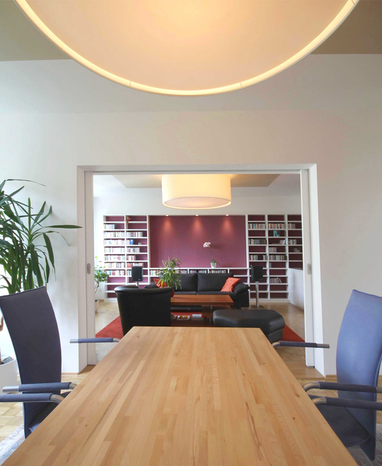 Der breite Wanddurchbruch mit Schiebetüren führt Speisezimmer und Wohnzimmer zusammen und schafft einen großzügigen Gesamtraum innerhalb der Wohnung.