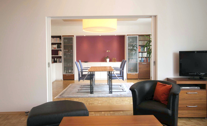 Das Wohnzimmer entspricht in seiner formalen Gestaltung der Ausführung des Speisezimmers, beide Raumbereiche ergänzen sich gemeinsam zu einem großzügigen Salon.