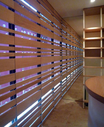 Raumhohe Spiegel zu beiden Seiten der beleuchteten Türen steigern die Raumwirkung optisch ins Unendliche. Die Weinregale bestehen aus Plexiglas, Beleuchtung durch LED.