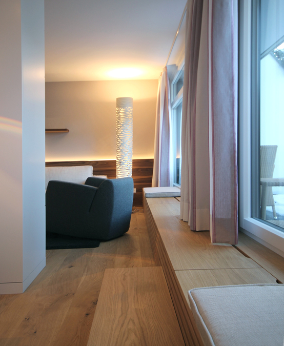 Die niedrige Heizkörperverkleidung läuft entlang der Fassade und bildet den Übergang vom Schlafzimmer zum Wohnzimmer, sie dient als Austritt zur Terrasse und als Sitzfläche.  